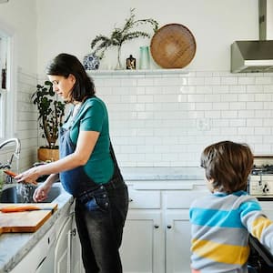 Mom cooks dinner with son in beautiful kitchen