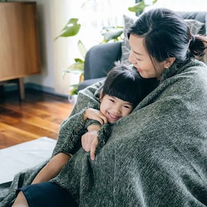 Mother and daughter wrapped in a blanket