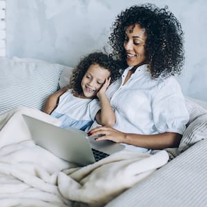 Mother and little daughter snuggling on the couch