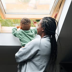 Mother and baby open window fresh air