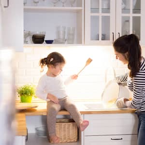 Mother and daughter laughing at kitchen sink