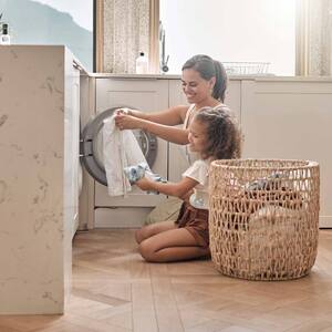 A mother doing the laundry with her daughter