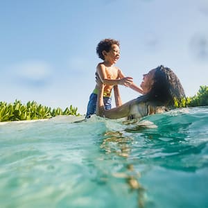 laughing mother and son playing in pool