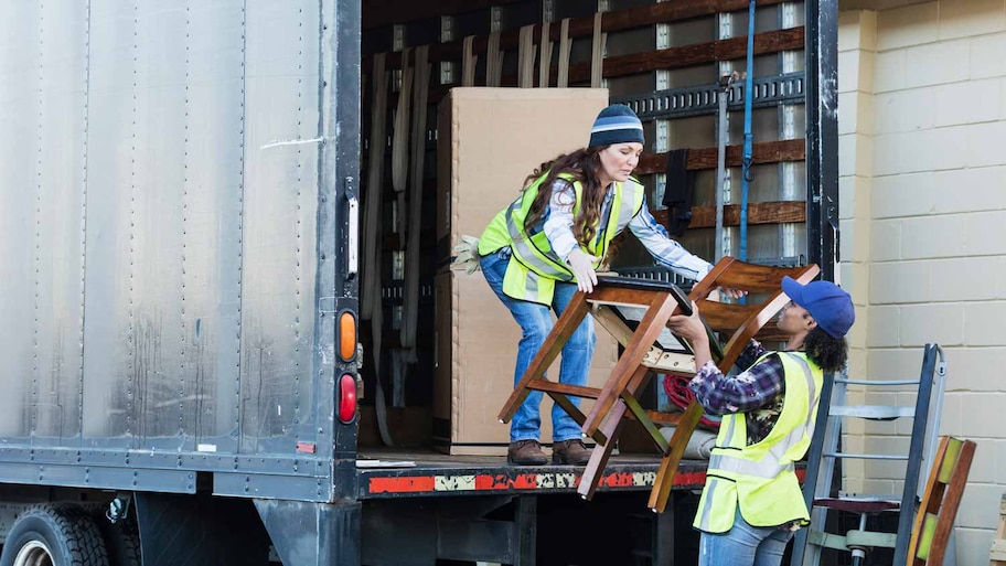 Two movers loading a truck with furniture