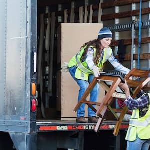 Two movers loading a truck with furniture