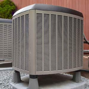 Air conditioner units on concrete slab outside the house