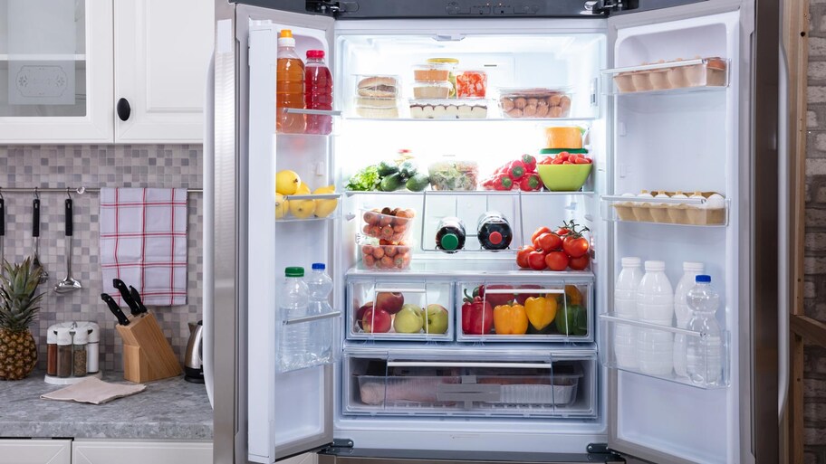 An open fridge with various fruit and vegetables