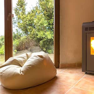 Pellet stove with fire going installed by the patio door 