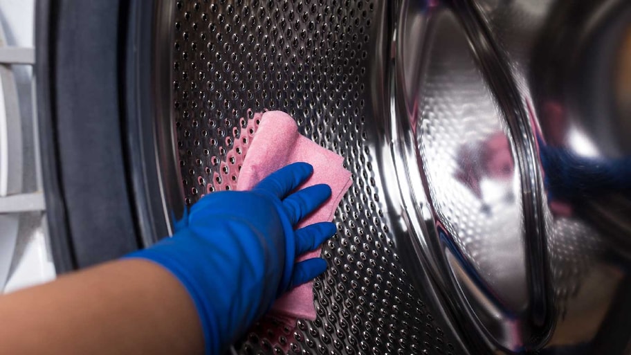  A person cleaning a washing machine drum