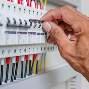 A person opening a circuit breaker