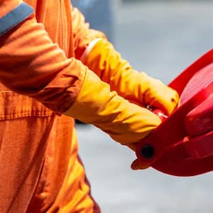 A person removing a hazardous waste bin