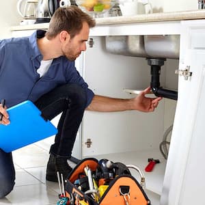 Plumber checking kitchen's plumbing