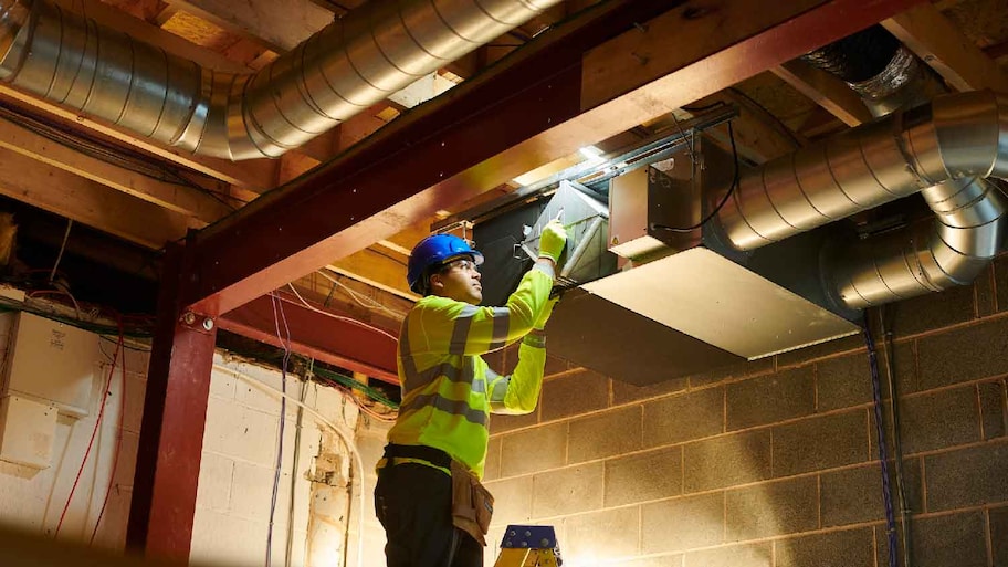 A professional cleaning an air duct 