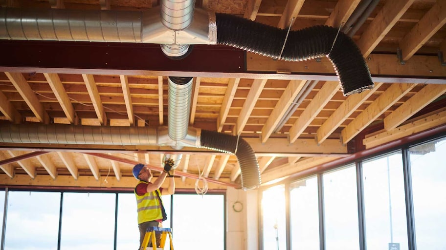 A professional inspecting ductwork 