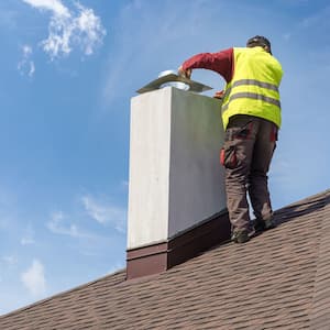 A professional sealing a chimney cap