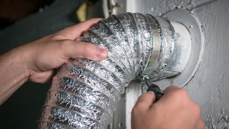 A professional tighting the screws on a vent hose