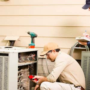 Two professionals installing new AC unit