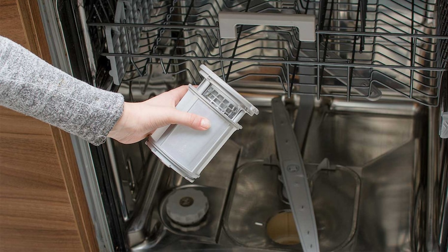 A view of someone removing a dishwasher filter