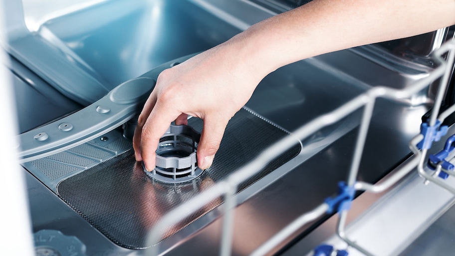 Closeup of a person removing dishwasher filter