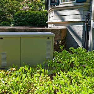 A residential standby generator in the backyard of a house