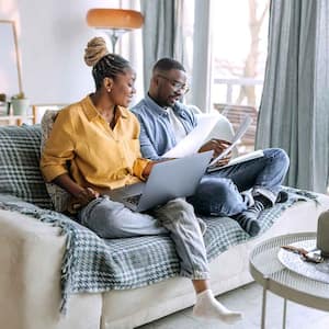 Couple sitting on the couch going over paperwork