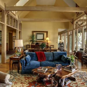 A living room with vaulted ceiling and large windows