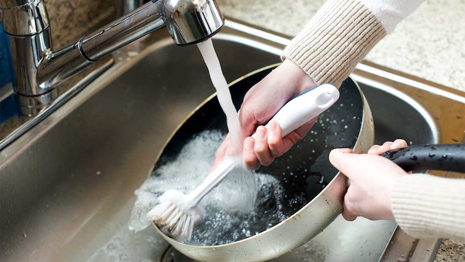 Scrubbing a pan in a sink