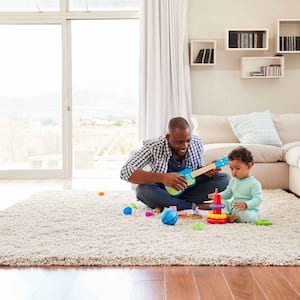 Dad sitting on a rug playing with his son