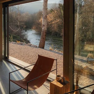 A living room with sliding glass doors overlooking a river