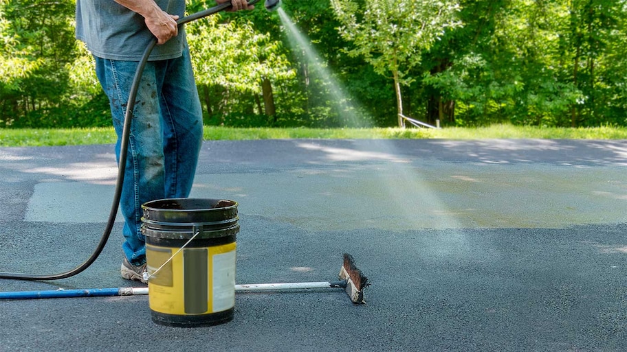 Spraying water on the driveway with a hose