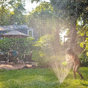 Backyard sprinkler water child