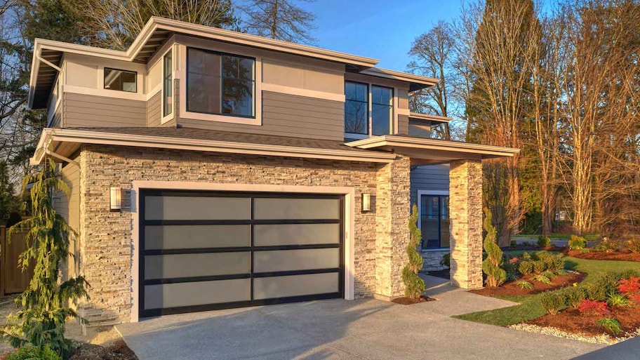 A stone veneer house with a glass garage door