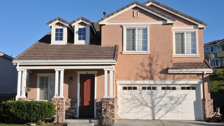 Stucco and brick house with maroon door