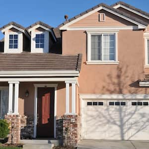 Stucco and brick house with maroon door