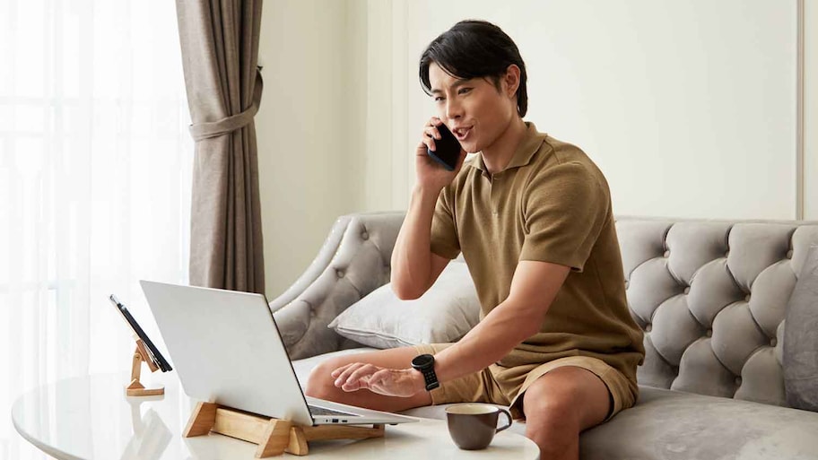 Young man sitting on the couch talking on the phone