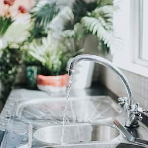 A silver tap running water on a sunny day