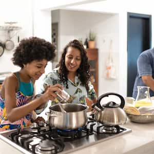 Mother teaching teenager daughter how to cook 