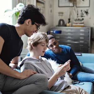 Teenager boys sitting on a couch using their phone