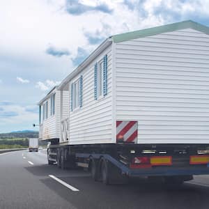 Driving behind heavy-duty truck carrying two prefabricated houses