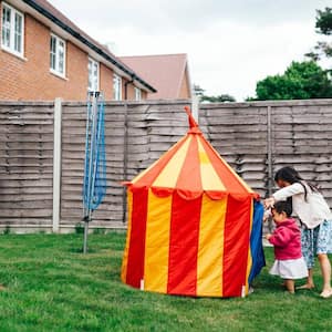 Two girls getting in a tent in their yard