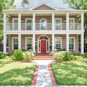 A two-story colonial house with a red front door