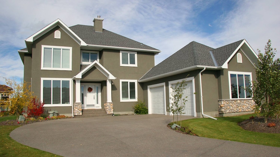 Two-story stucco house with concrete drive