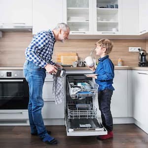 Grandpa and grandson unloading the dishwasher