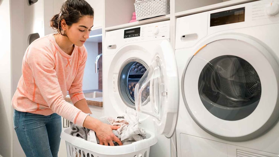 Young woman unloading dryer machine