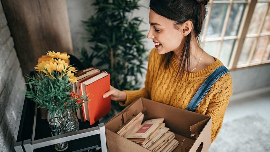 Woman arranging books on bookshelf