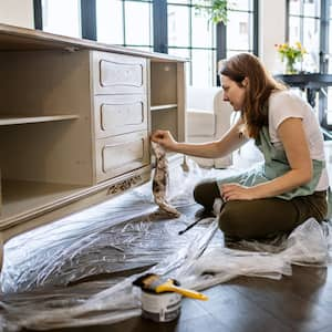 Young woman repairing an old furniture