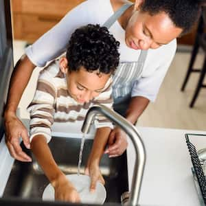 Mother and son washing dishes together