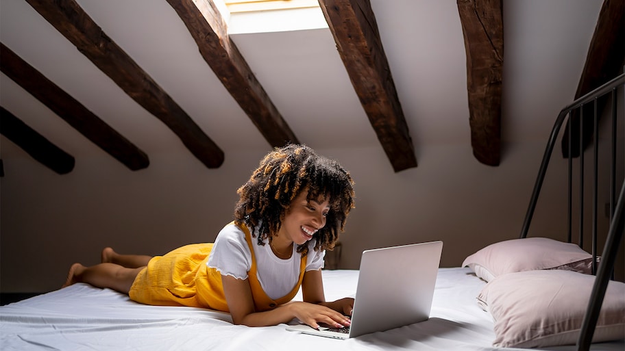 Woman laying on bed in attic.