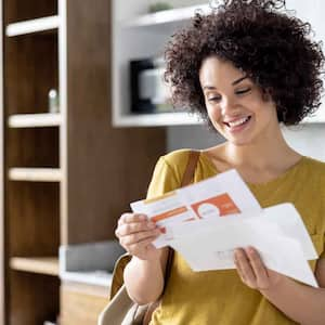 Happy woman checking mail at home