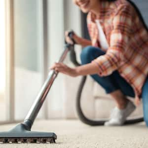 close up woman cleaning carpet  